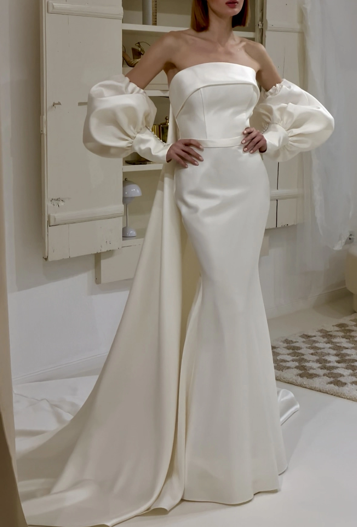 Modernes A-Linien-Brautkleid mit markantem, gerafftem Bolero-Element und abgesetzter Taille – modischer Twist zwischen Klassik und Avantgarde.