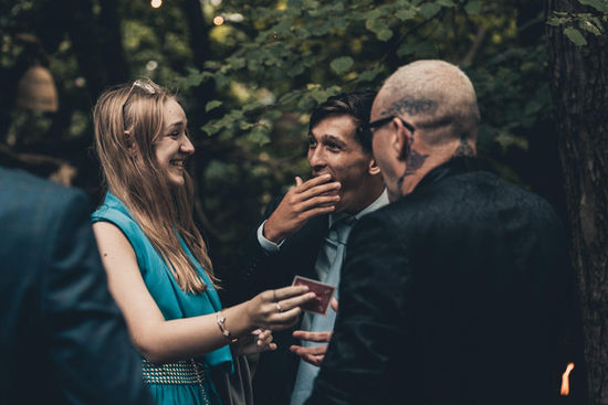 Wedding guests laughing as Adam Smith performs
close up magic at Wilderness Weddings for Nicola and James wedding