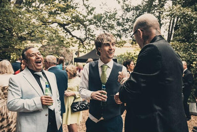 Wedding guests laughing as Adam Smith performs
close up magic at Wilderness Weddings for Nicola and James wedding