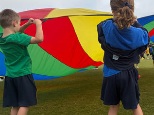 Kids playing with rainbow parachute