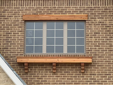 Unfinished exterior cedar rail, planter box and corbels installed under a window