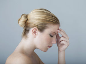 An older blonde woman with a headache