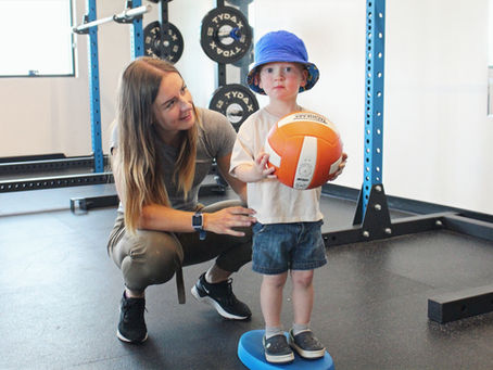 Child practicing gross motor skills with a pediatric physiotherapist