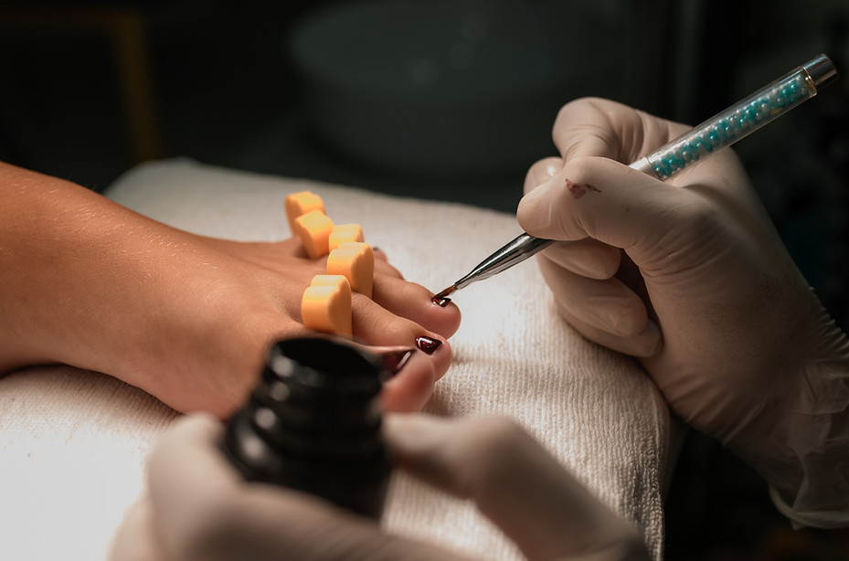 Young woman getting professional pedicure in beauty salon, closeup.