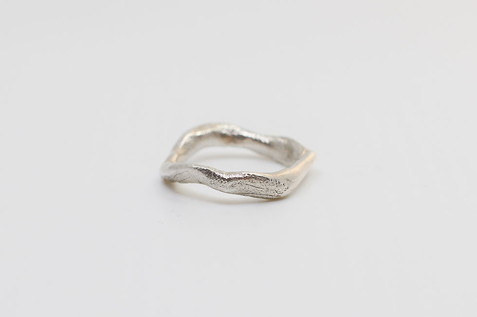 Front view of handcrafted sterling silver ring with wave design.