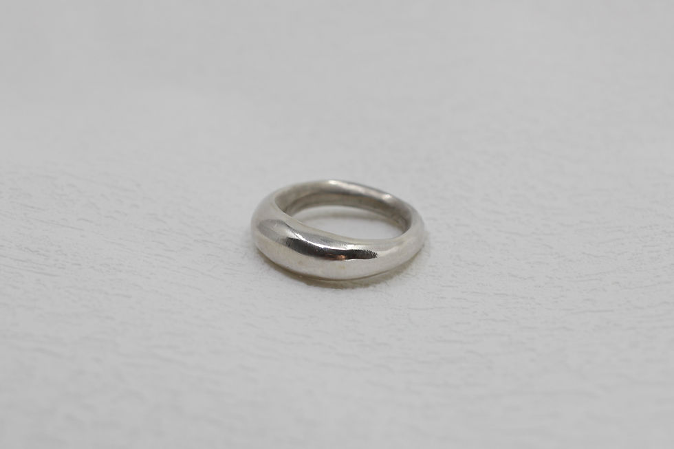 Front view of a handmade lamp ring made of sterling silver and polished with brushed details.
