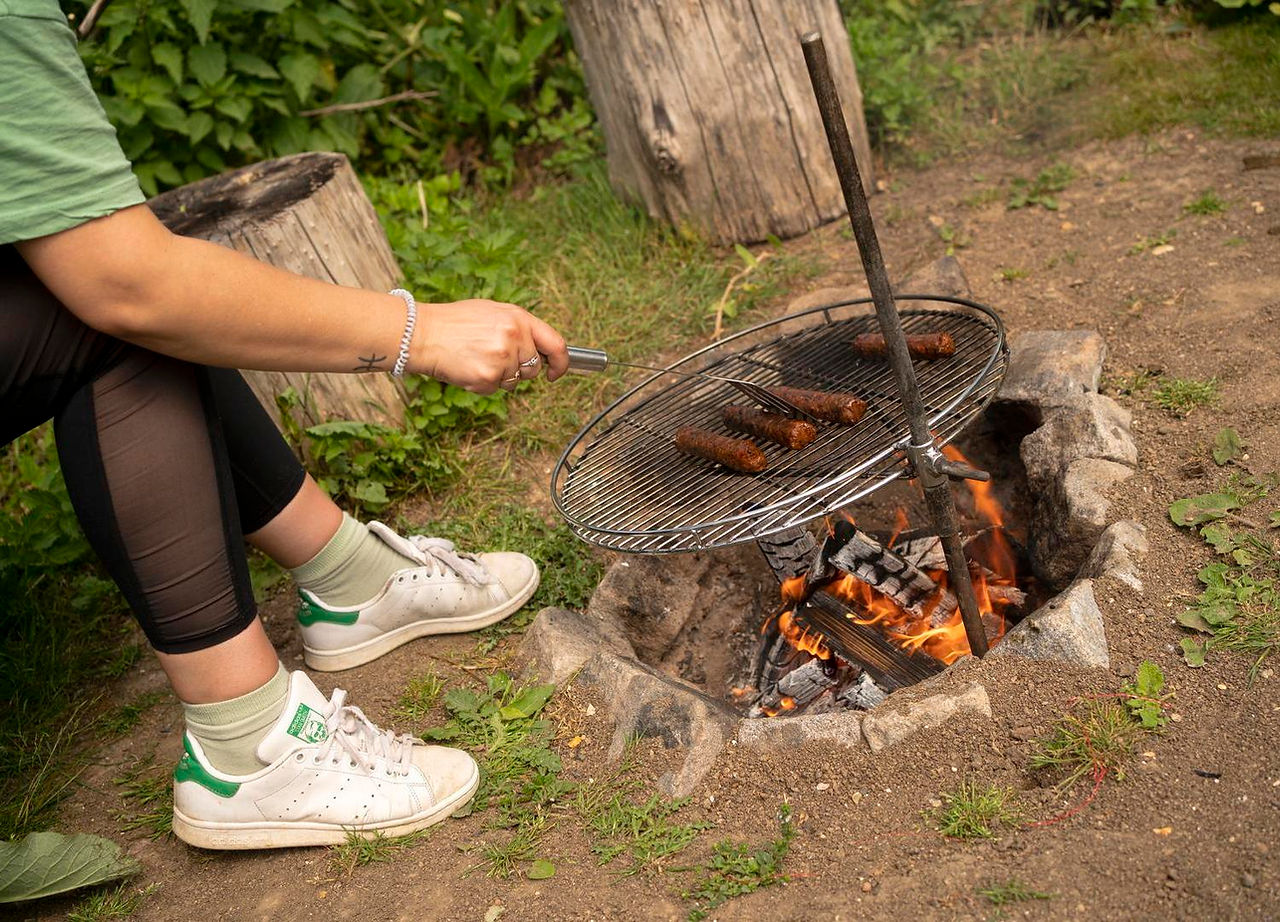 Open fire burning in fire pit with cooking grill over it