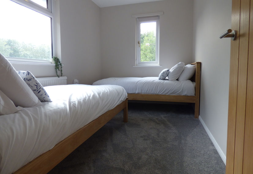 Twin beds made up with white bed linen