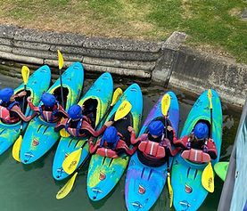Six participants in kayaks on the lake