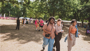 Group people walking on grassed area with trees in the background at a festivel