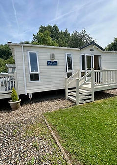 Side view of beige holiday home with decking running to the front of it