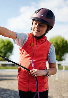 Child wearing red jacket and riding hat