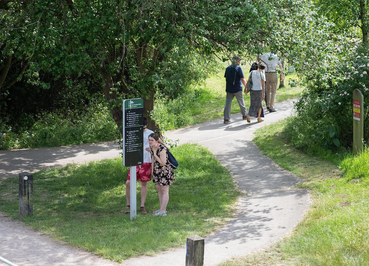 People looking at a directional signpost in River Lee Country Park