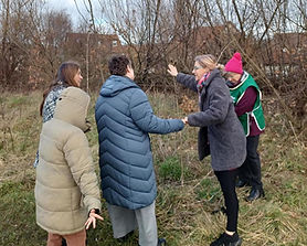 Three people wearing coats on a sensory walk