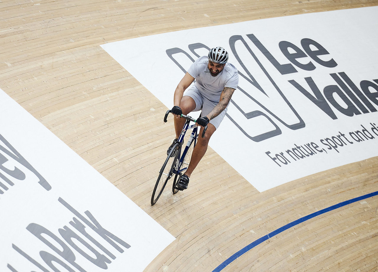 Person riding a biked on the sloped velodrome track at Lee Valley VeloPark