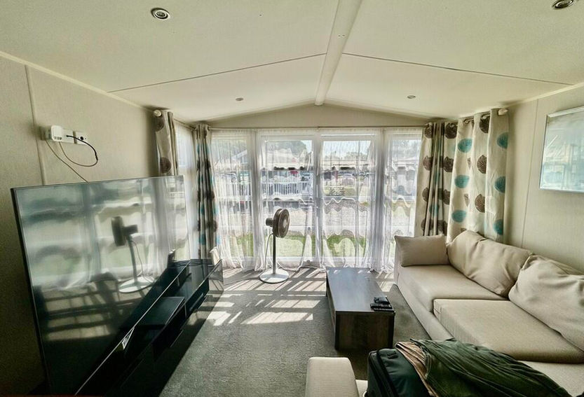 Open plan living room and kitchen area facing the bay windows
