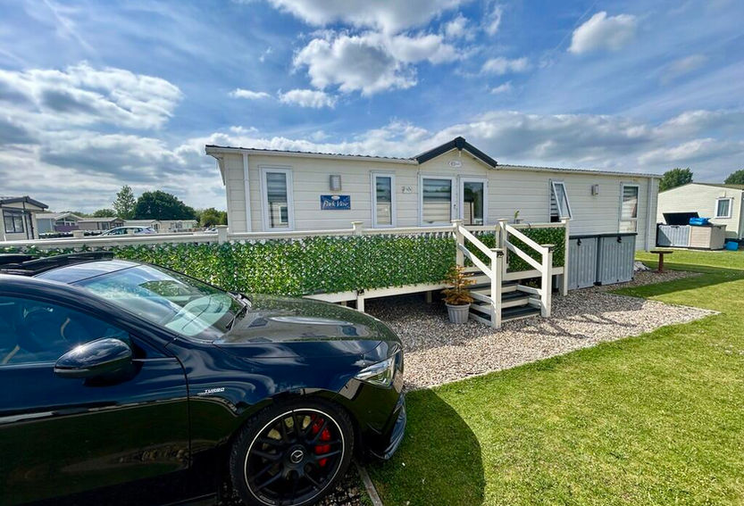 Cream static caravan with raised decking and steps