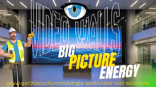 Security installer in hard hat and vest points at large video wall with text "VIDEO WALLS BIG PICTURE ENERGY". URL below. Modern lobby.