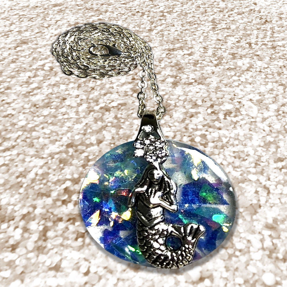 Silver necklace with blue and silver pendant, sparkling on a beige surface, KCM Gifts4You.