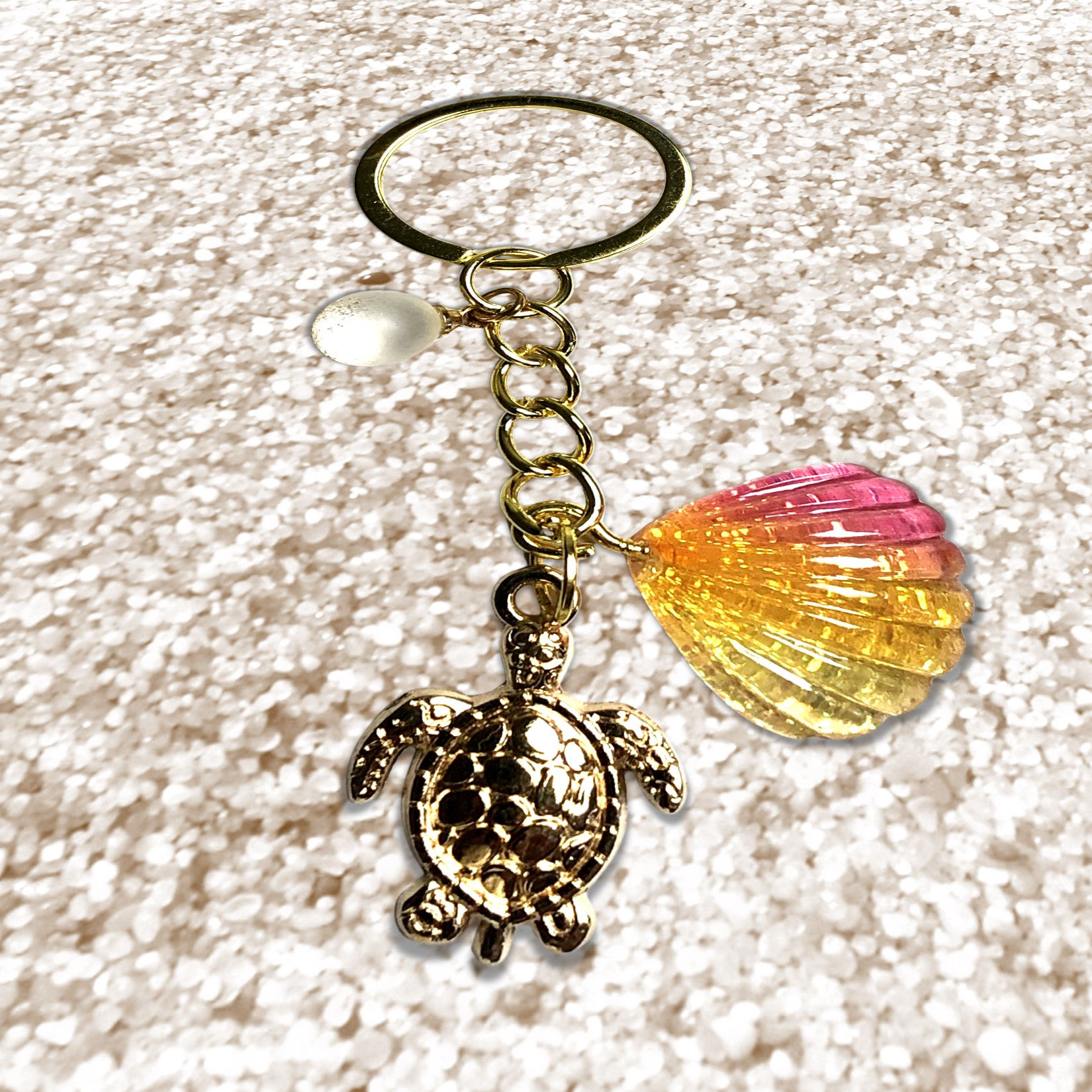 Key chain featuring a turtle charm and Holographic with Apple Charm on a surface.