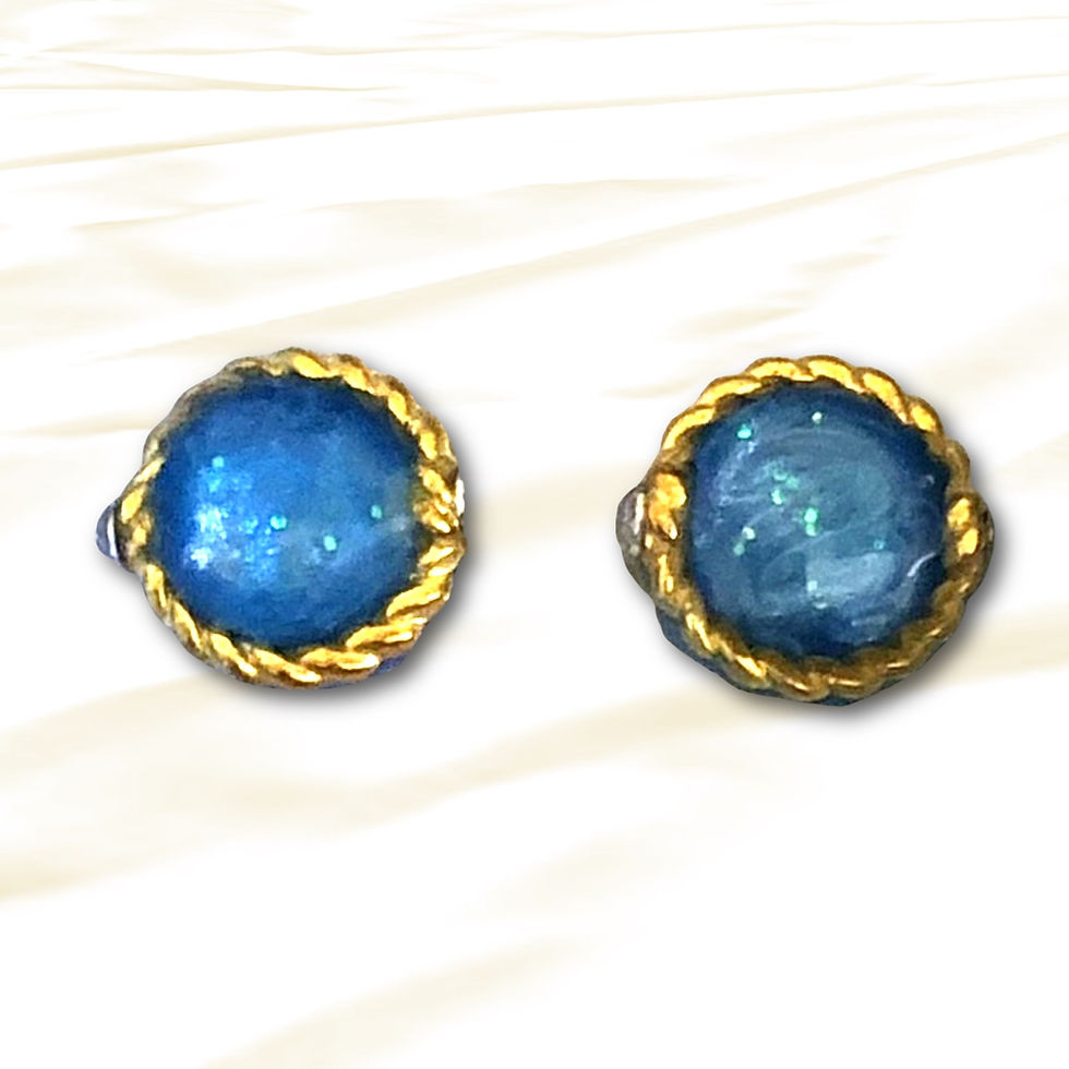 Sparkling blue resin stud earrings with gold trim, close-up with light background.