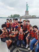 Group of students on boat, Statue of Liberty in background, New York Harbor School.