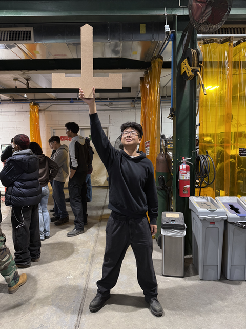 Student holding large letter L, NY Harbor School