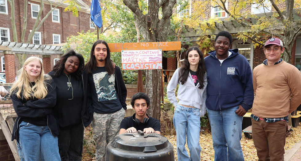 Seven students pose by the NYHS community garden