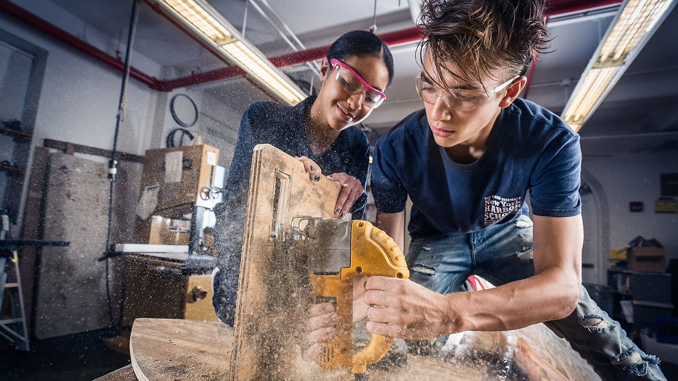 Students using hand saw in woodshop class, phot by Von Wong