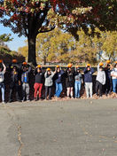 Group of students holding pumpkins in front of the New York Harbor School
