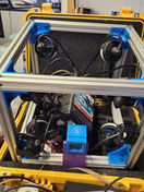 Open yellow equipment case with complex cameras and supporting electronics components.