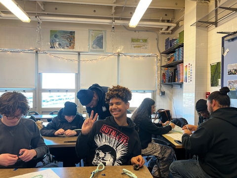 Smiling student showing peace sign in classroom