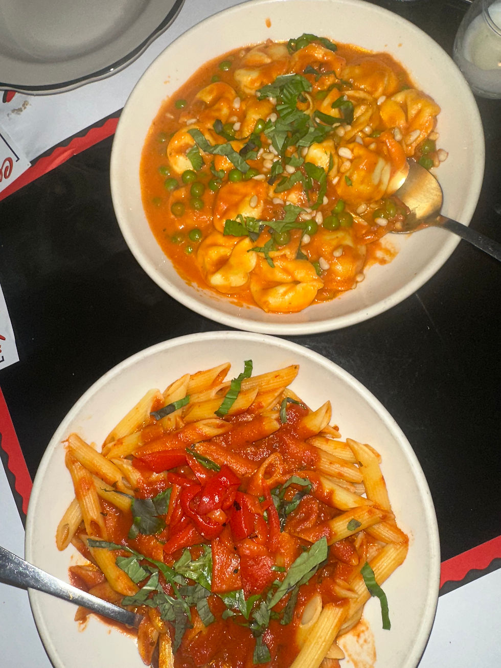 Penne arrabbiata pasta in a red spicy tomato sauce garnished with basil
Homemade tortellini in vodka sauce, topped with Parmesan cheese