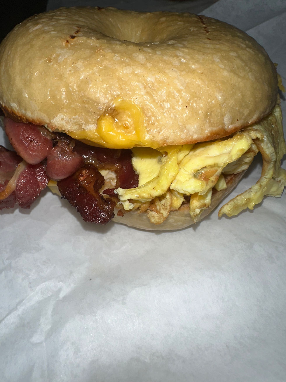 Breakfast sandwich with eggs, bacon, and melted cheese at Olive and Oak Cafe in Chicago.