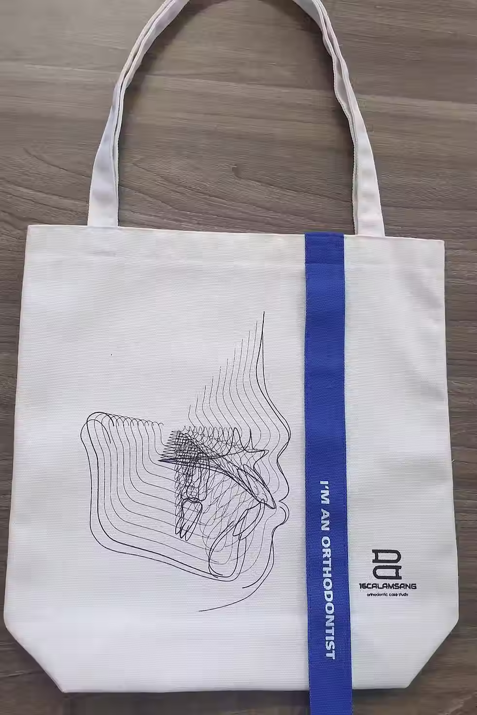 Thumbnail: White tote bag with dental design and blue vertical text