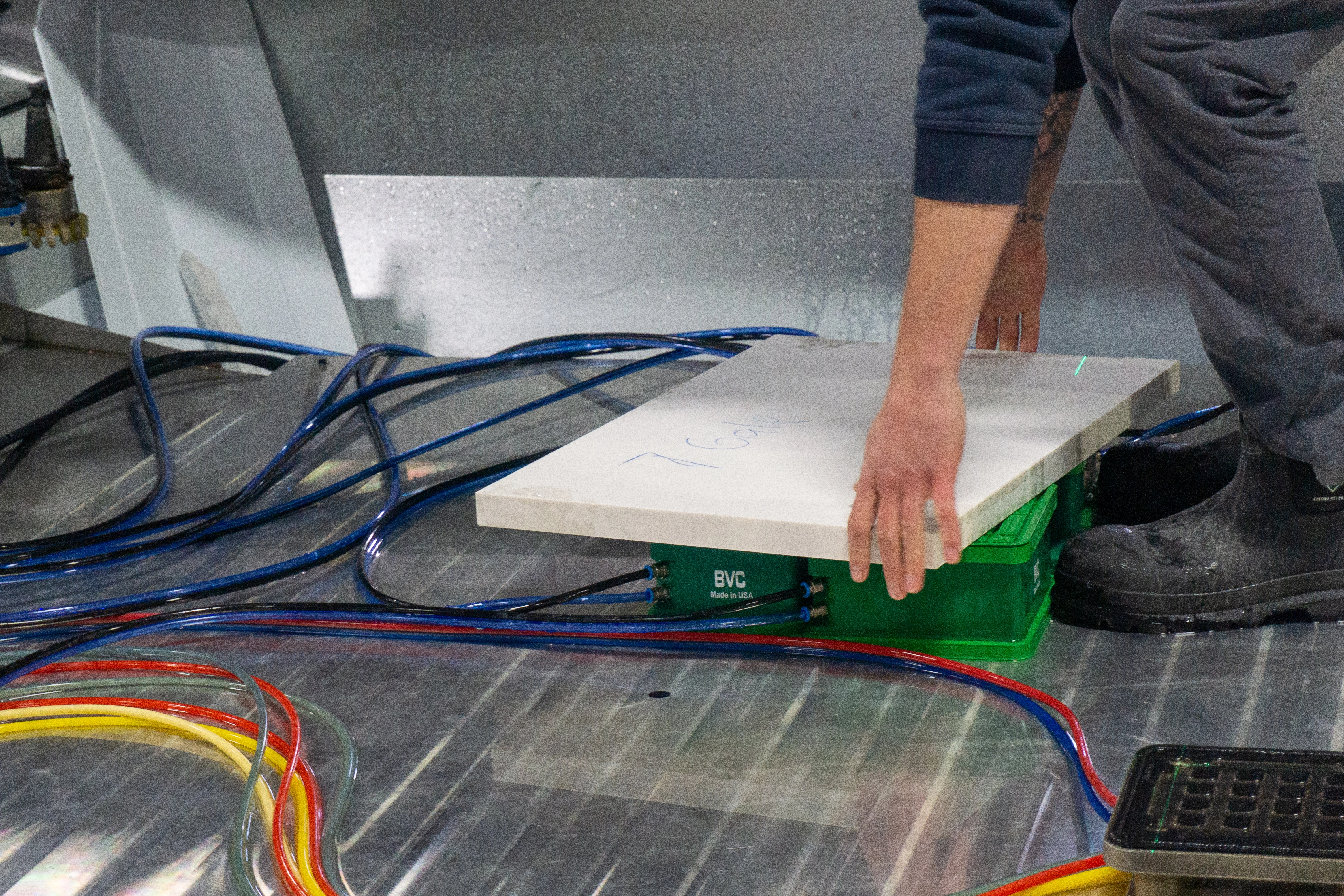 Better Vacuum Cups (BVC) holding a quartz slab as it is placed onto the Paladin CNC stone mill table