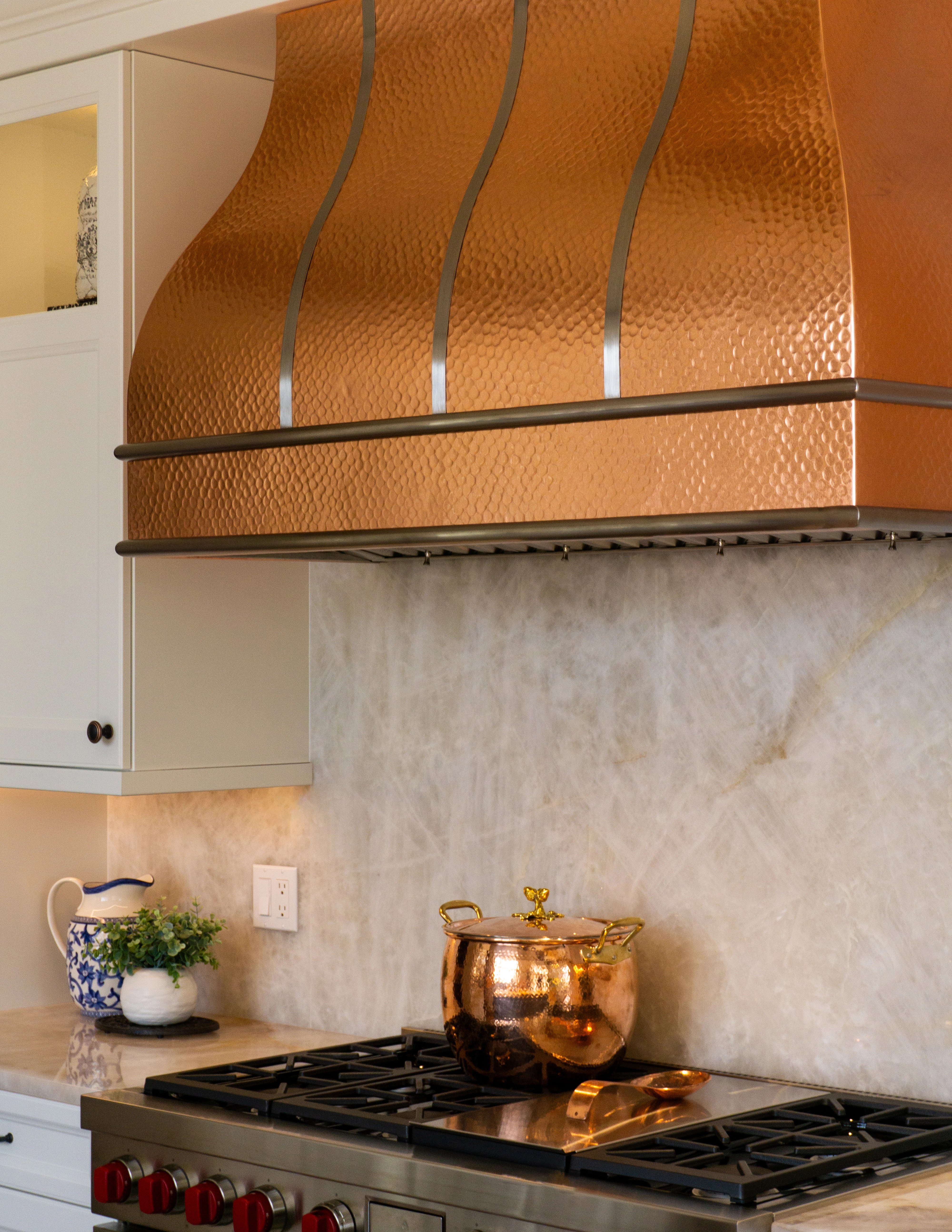 Full height quartzite backsplash on the kitchen perimeter showcasing seamless veining and polished stone surfaces.