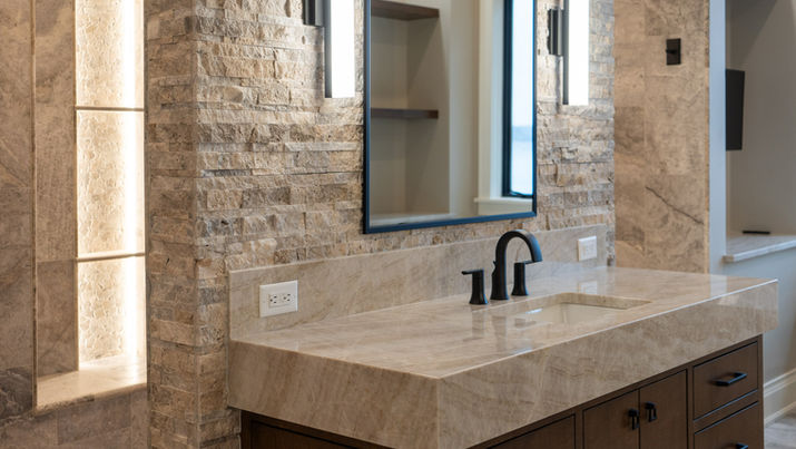 Bianca Perla Quartzite vanity countertops with drop miters in the master bathroom of a home in Hartland, WI, featuring a sleek and sophisticated design.