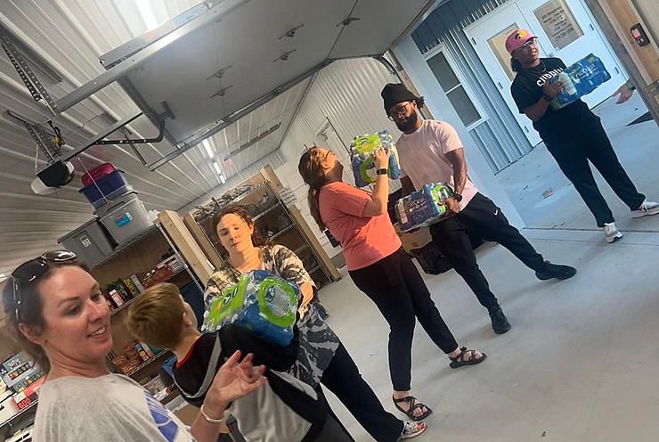 A group of volunteers unloading emergency supplies off a truck.
