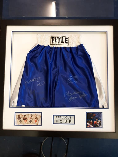 Framed blue boxing trunks signed by multiple athletes