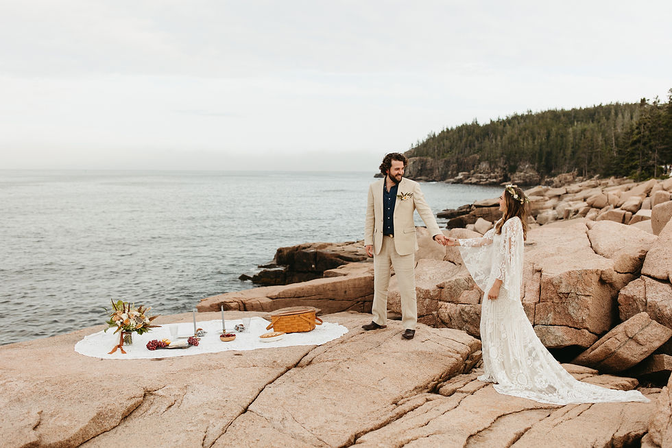 A bride and groom enjoy an elopement picnic near Thunder Hole in Acadia National Park in Maine.