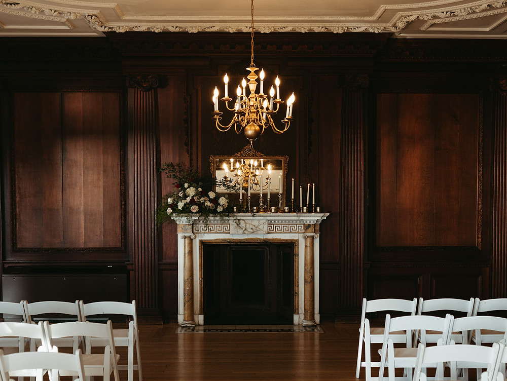 The fireplace at the Branford House is decorated with candles and flowers at this Connecticut wedding.