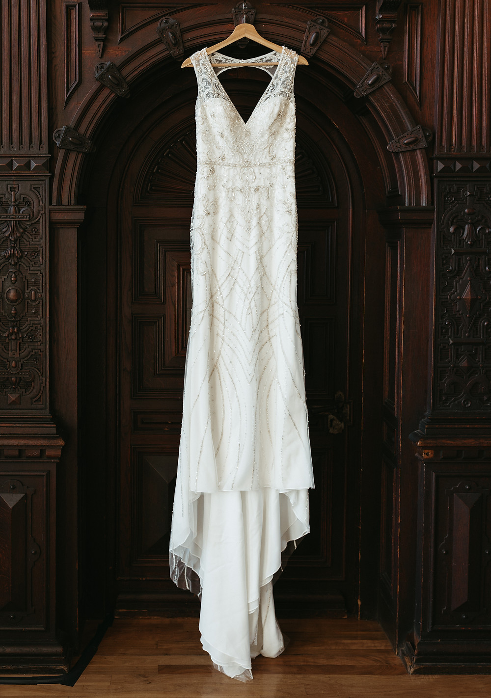 A 1920's inspired beaded gown hangs in the doorway of the Branford House at a Connecticut wedding.