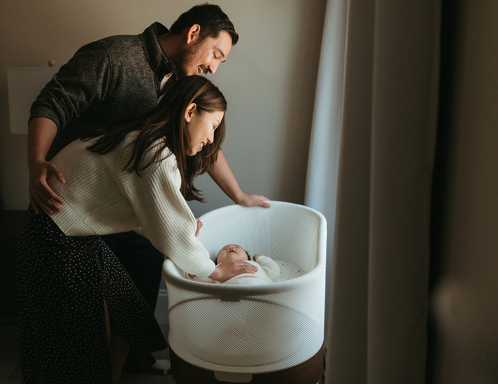 Couple admires their newborn at their in-home family session.