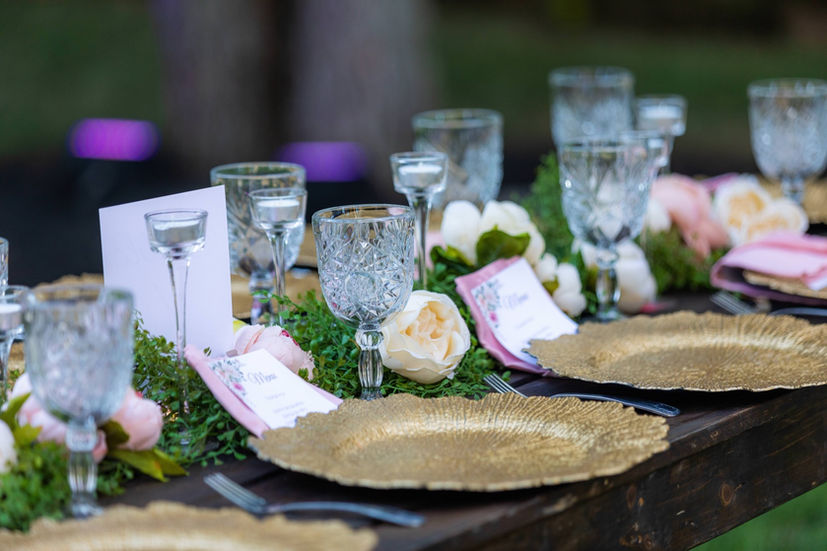 Crystal glassware and gold chargers creating a timeless, elegant reception table.