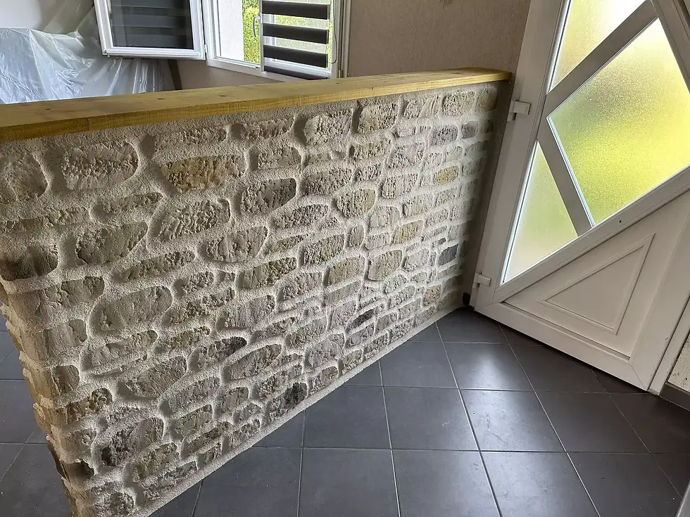 Mur en pierre sculptée à la main dans une entrée de maison, avec tablette en bois