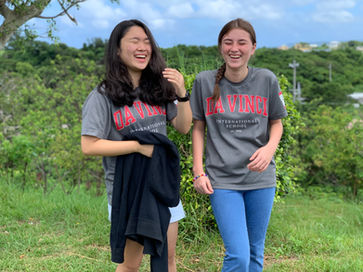 Two DA·VINCI students smiling together during an outdoor school activity in Okinawa