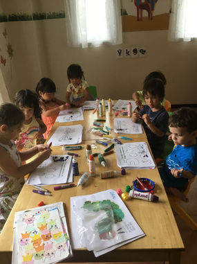 Alunos da pré-escola desenhando e criando arte juntos em uma sala de aula DA·VINCI.