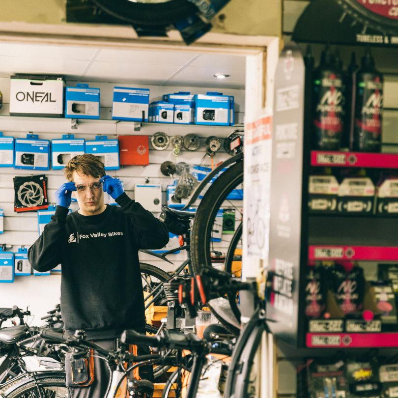 Miro in the shop with helmets and accessories on the wall