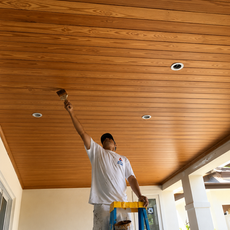 Professional wood ceiling staining contractor applying premium stain to a luxury tongue-and-groove wood ceiling on a covered patio in Palm Beach, Florida.